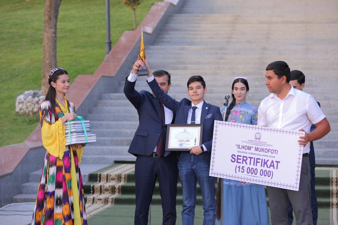 Asadbek receiving the Ilhom Award trophy and 15,000,000 so'm certificate